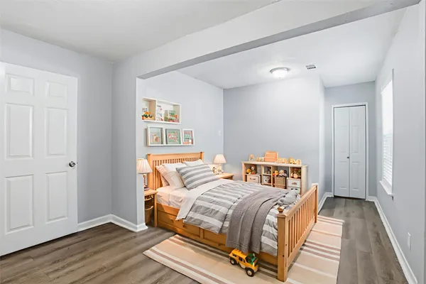 a bedroom with a bed and wooden floor