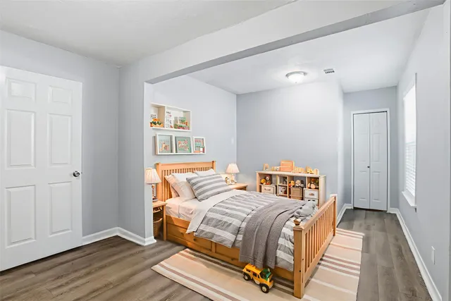 a bedroom with a bed and wooden floor