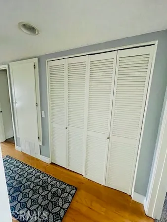 a view of a room with wooden floor and small window