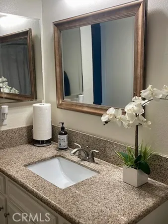 a bathroom with a granite countertop sink and a mirror