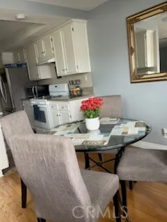 a kitchen with stainless steel appliances granite countertop a table chairs sink and cabinets