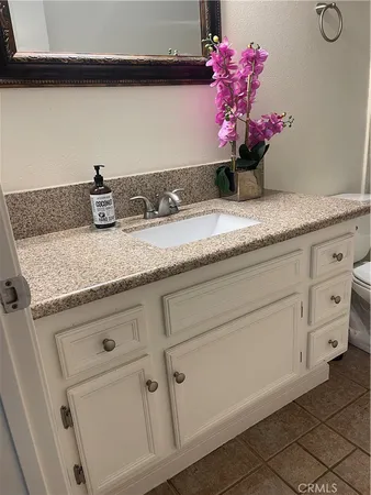 a bathroom with a granite countertop sink a vanity and mirror