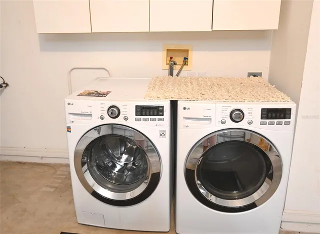 a patio with table and chairs and potted plants