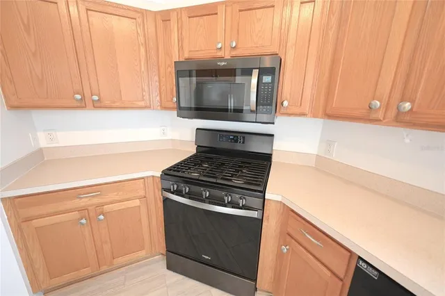 a kitchen with stainless steel appliances kitchen island a refrigerator sink and microwave