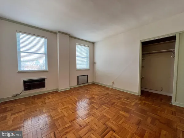 a view of an empty room with window and closet area