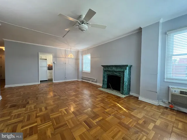 a view of an empty room with window and fireplace