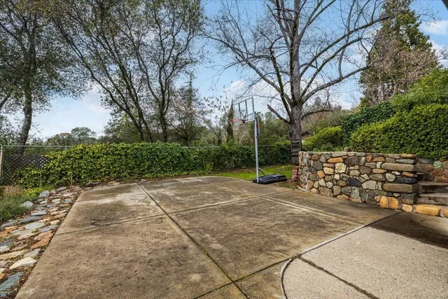 a view of a patio with a bench and trees