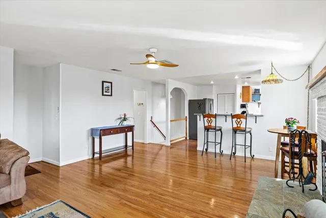 a living room with furniture and kitchen view with wooden floor