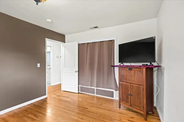 a view of a livingroom with wooden floor and a flat screen tv