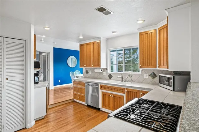 a kitchen with stainless steel appliances granite countertop a sink stove and refrigerator