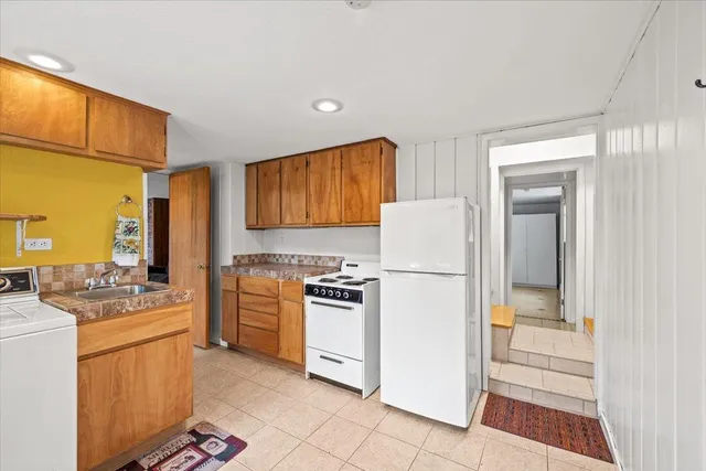 a kitchen with white cabinets and white appliances