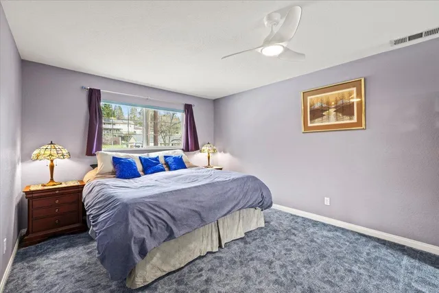 a bedroom with a bed and a painting on the wall