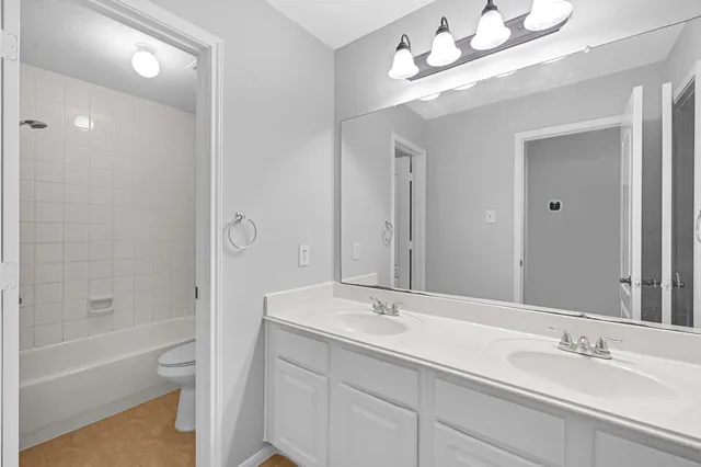 a bathroom with a sink double vanity granite tub and shower