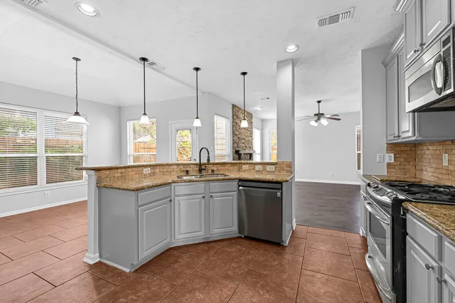 a kitchen with stainless steel appliances granite countertop a stove and a sink
