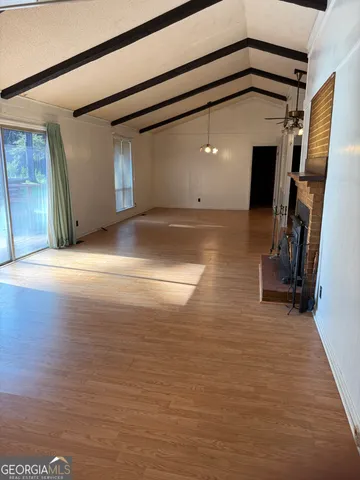 a view of a livingroom with wooden floor and a fireplace