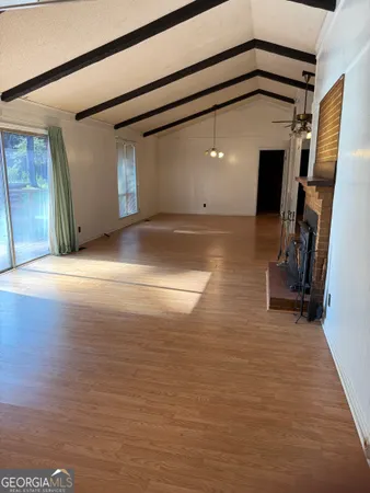 an empty room with a window and a ceiling fan