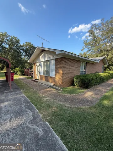 a front view of a house with a garden and yard