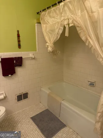 a view of a kitchen with kitchen island a sink wooden floor and a large window