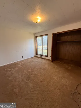 an empty room with closet and a ceiling fan