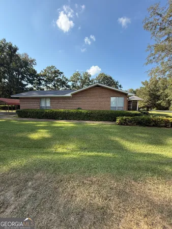 a front view of a house with a garden and yard