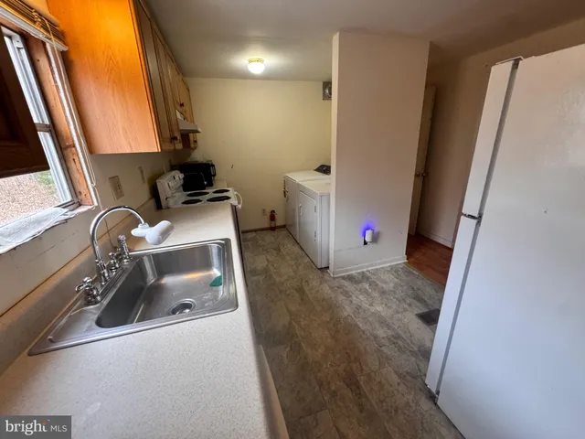 a view of kitchen with furniture and a refrigerator