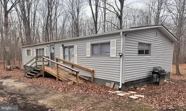 a view of a house with a yard and wooden fence