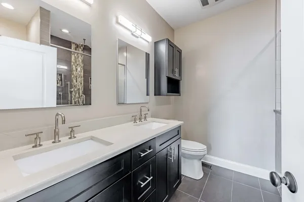 a bathroom with a double vanity sink mirror and toilet
