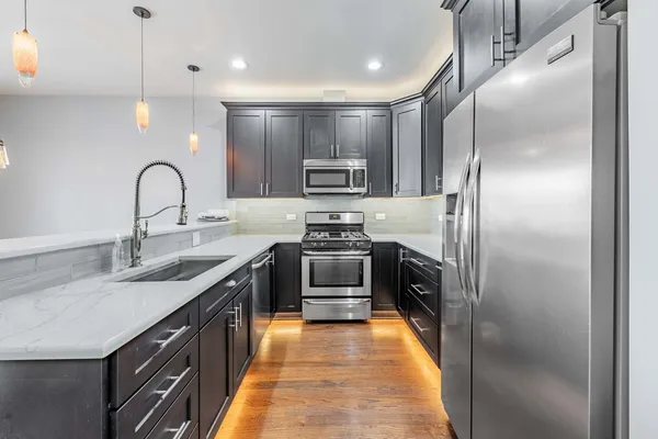 a kitchen with stainless steel appliances granite countertop a stove a sink and a refrigerator