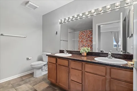 a bathroom with a double vanity sink and a mirror