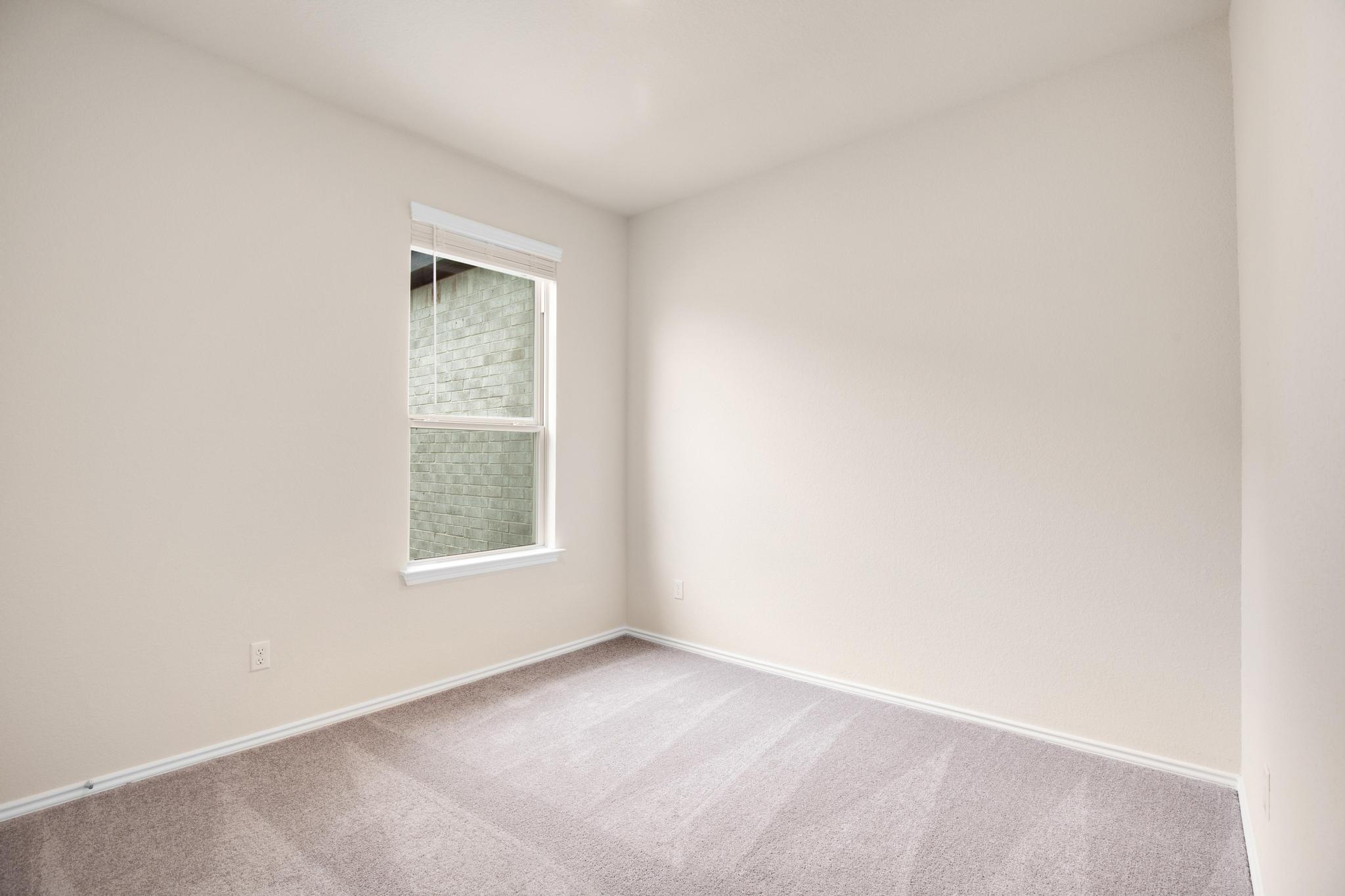 200 Janice Road Taylor, TX 76574 - Photo 21 of 25 An empty room offers a blank canvas for personalization, highlighted by a well-lit window.