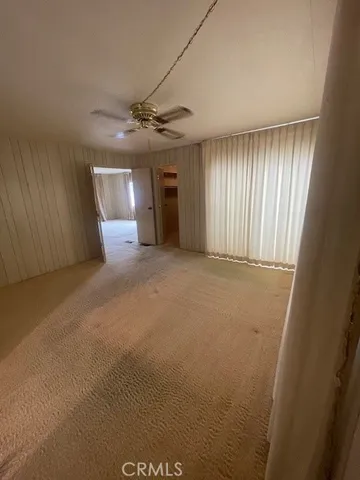 a view of a livingroom with a ceiling fan and window