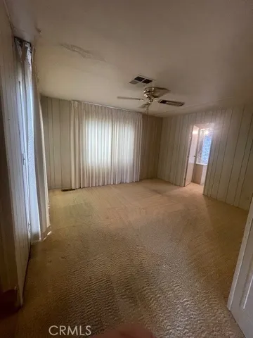 a view of a livingroom with a ceiling fan and window