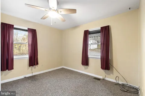 a view of an empty room with window and cabinet