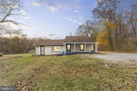 a view of a yard in front of a house with large tree