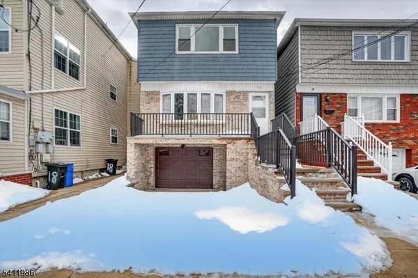 a view of a house with a barbeque and large trees