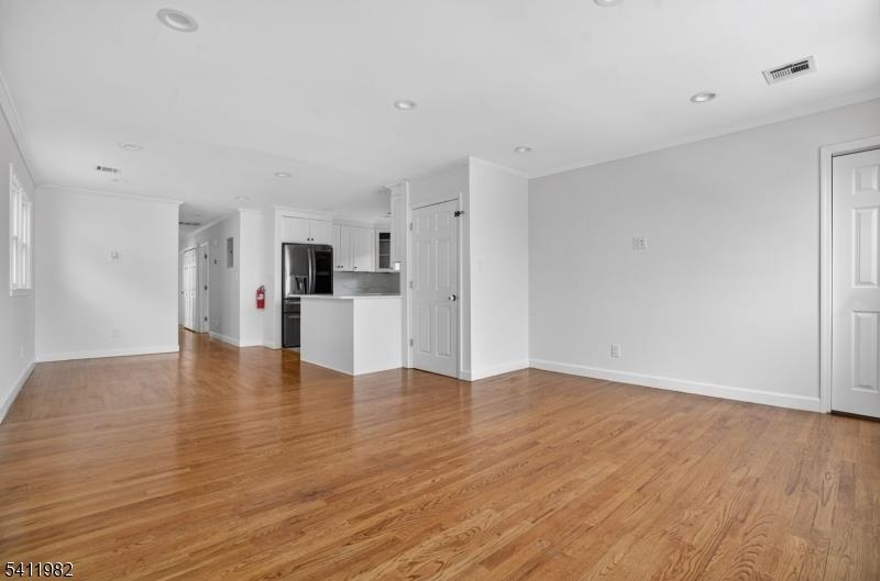 16 George Street, Unit 2 Bayonne, NJ 07002 - Photo 3 of 10 a view of a kitchen with a refrigerator and wooden floor