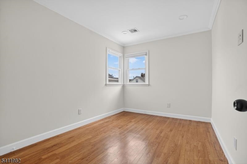 16 George Street, Unit 2 Bayonne, NJ 07002 - Photo 6 of 10 an empty room with wooden floor and windows