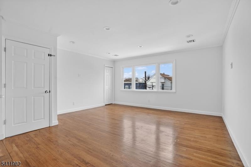 16 George Street, Unit 2 Bayonne, NJ 07002 - Photo 9 of 10 a view of an empty room with wooden floor and a window