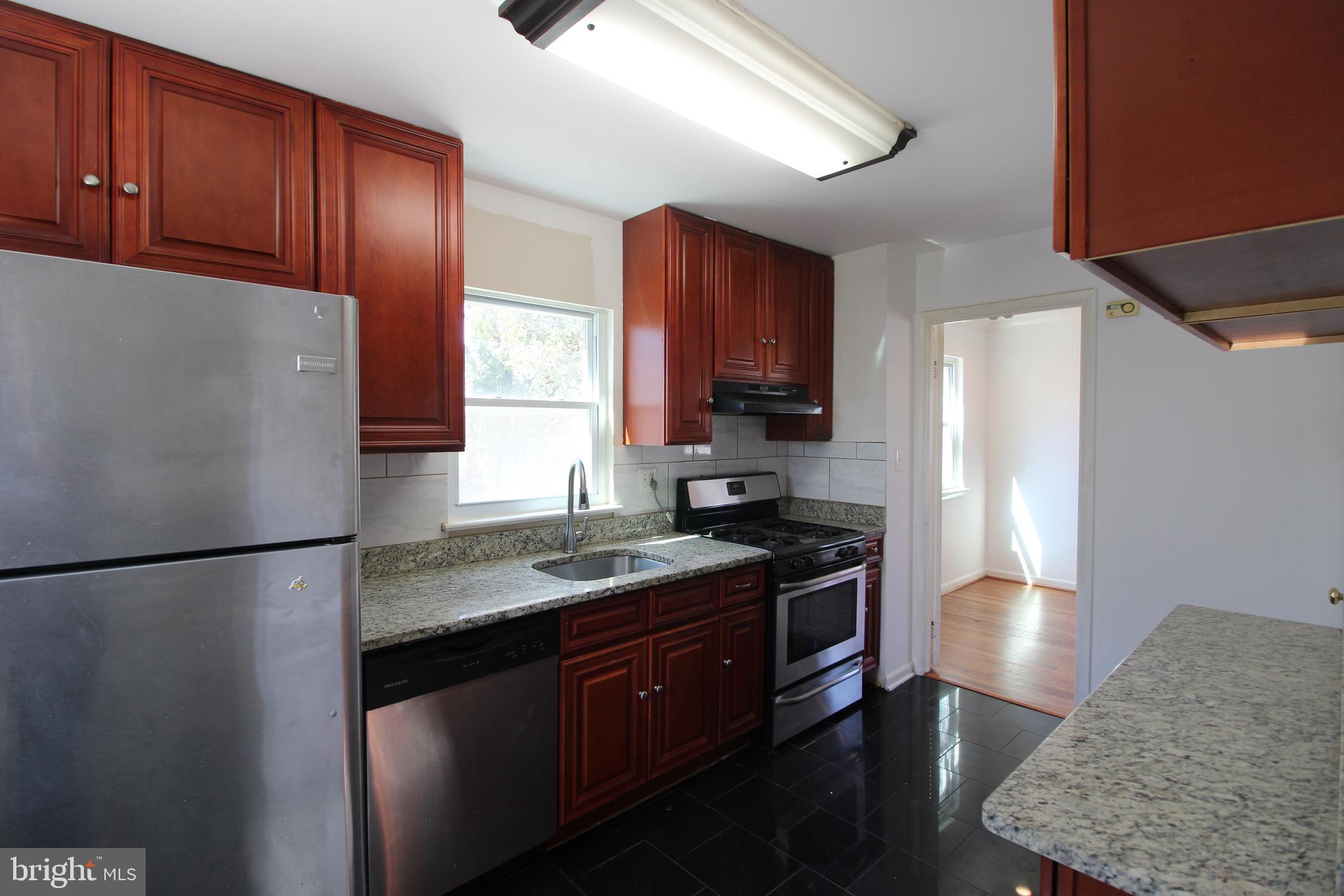 4416 Randolph Road Silver Spring, MD 20906 - Photo 8 of 27 a kitchen with a refrigerator stove and wooden cabinets