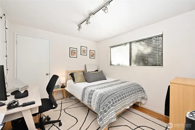 a bedroom with a bed and wooden floor