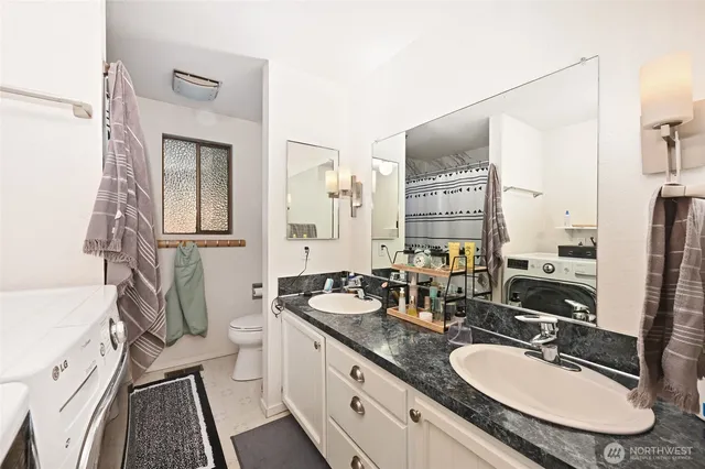 a bathroom with a granite countertop double vanity sink and a mirror