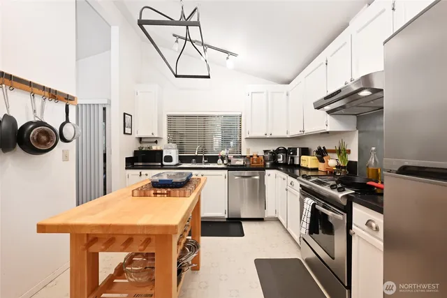 a kitchen with stainless steel appliances a stove a sink and cabinets