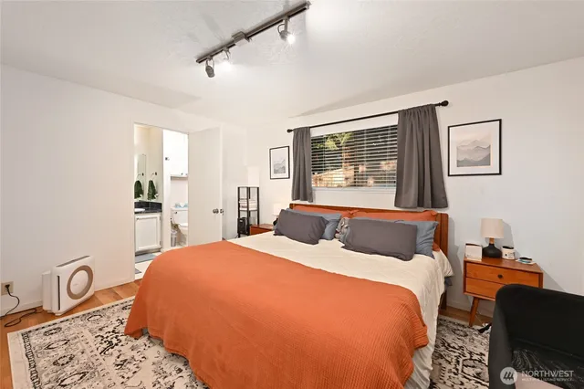 a bedroom with a bed and dresser with mirror