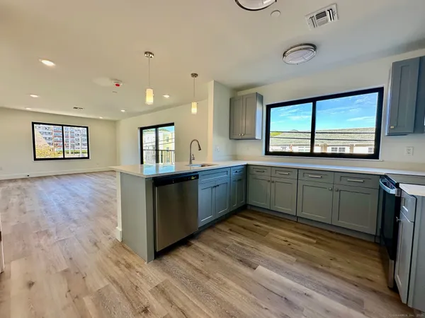 a view of a kitchen with wooden floor and a window