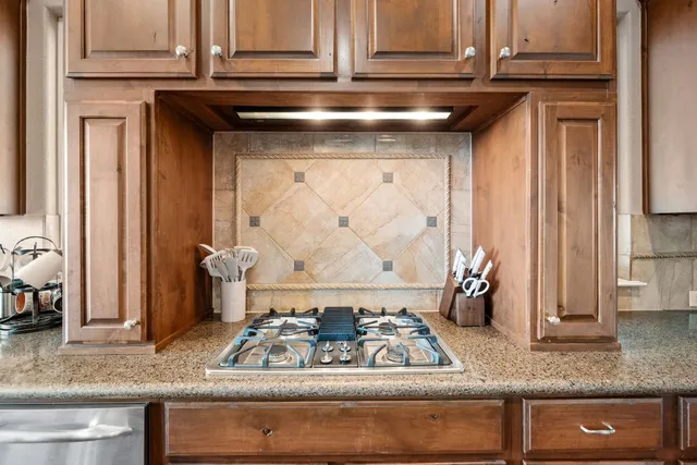 a view of a kitchen with kitchen island granite countertop a large counter top space and stainless steel appliances