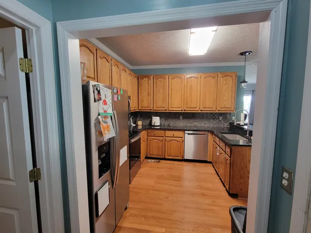 a kitchen with stainless steel appliances granite countertop a refrigerator and a sink