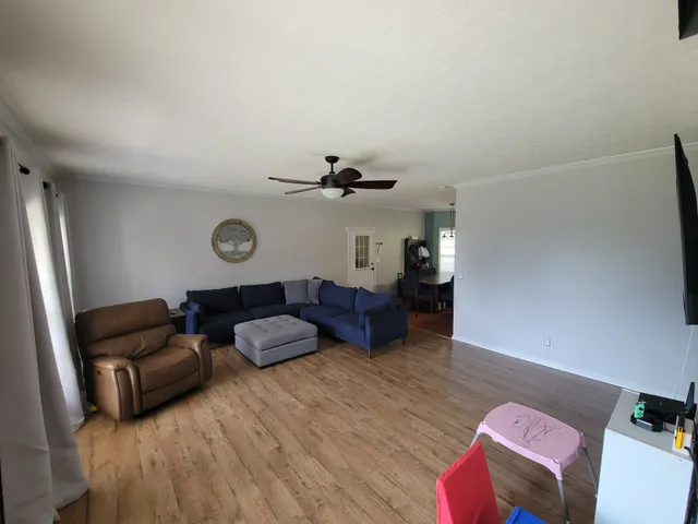 a living room with furniture and a wooden floor