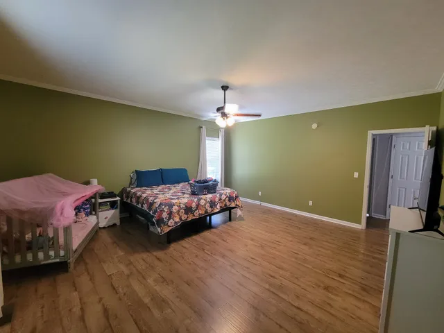 a bedroom with a bed and wooden floor