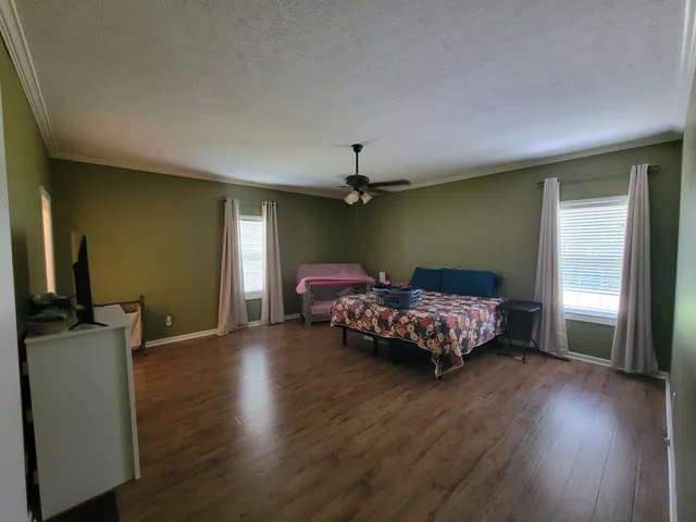 a bedroom with furniture and wooden floor