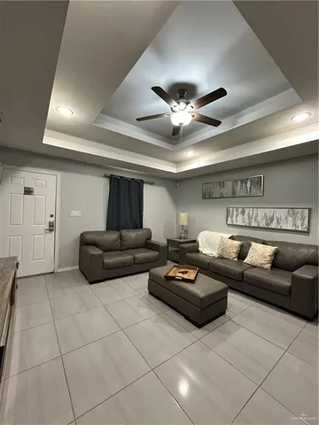 a living room with furniture and a ceiling fan
